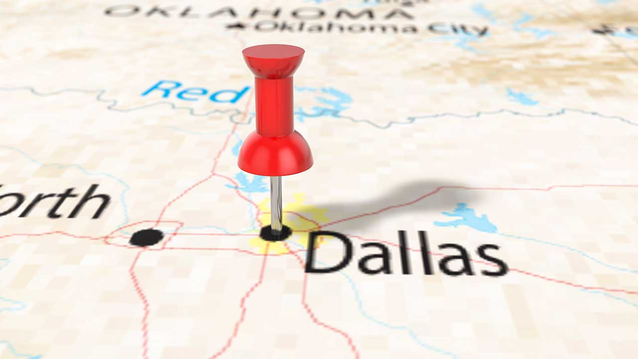 image of paper map with push pin stuck in Dallas, companies relocating to DFW